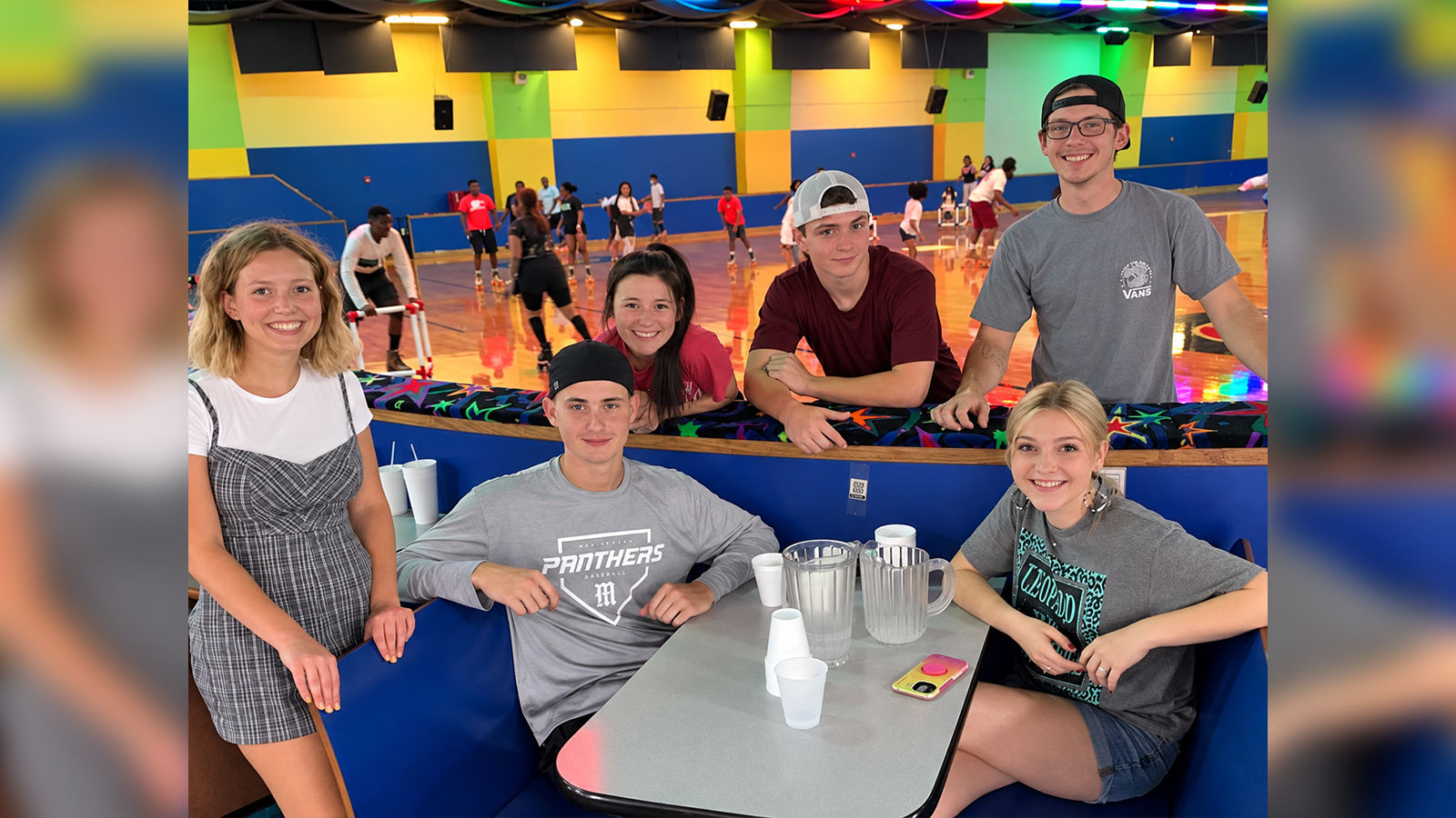 homeschool-roller-skating-arlington-skatium_1600x900 Group of smiling young adults gathered around a table beside the roller skating rink at Arlington Skatium in Arlington, TX.