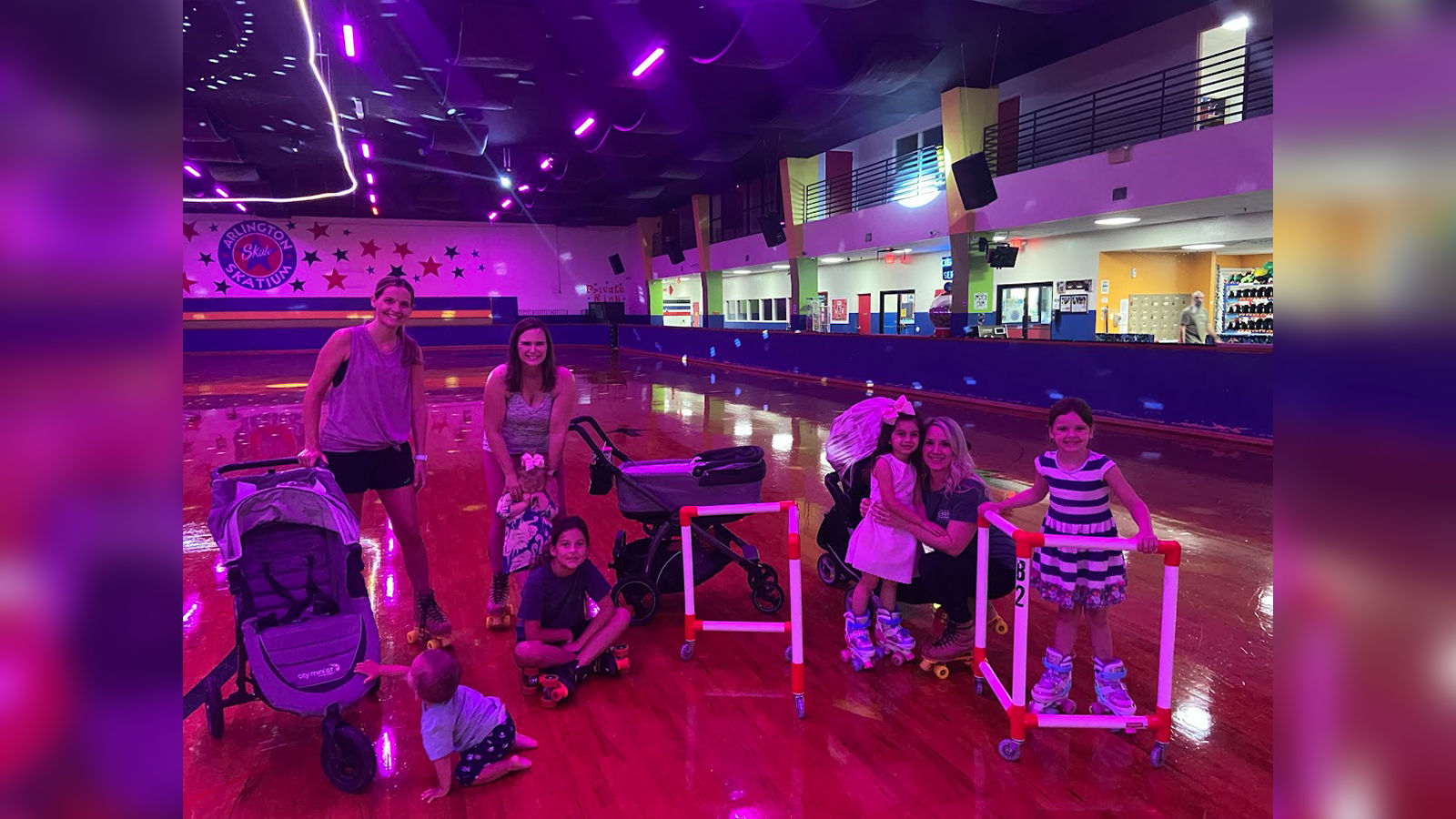 toddler-family-roller-skating-arlington-skatium_1600x900 Families with toddlers and young children enjoying roller skating with skate trainers and strollers at Arlington Skatium in Arlington, TX.